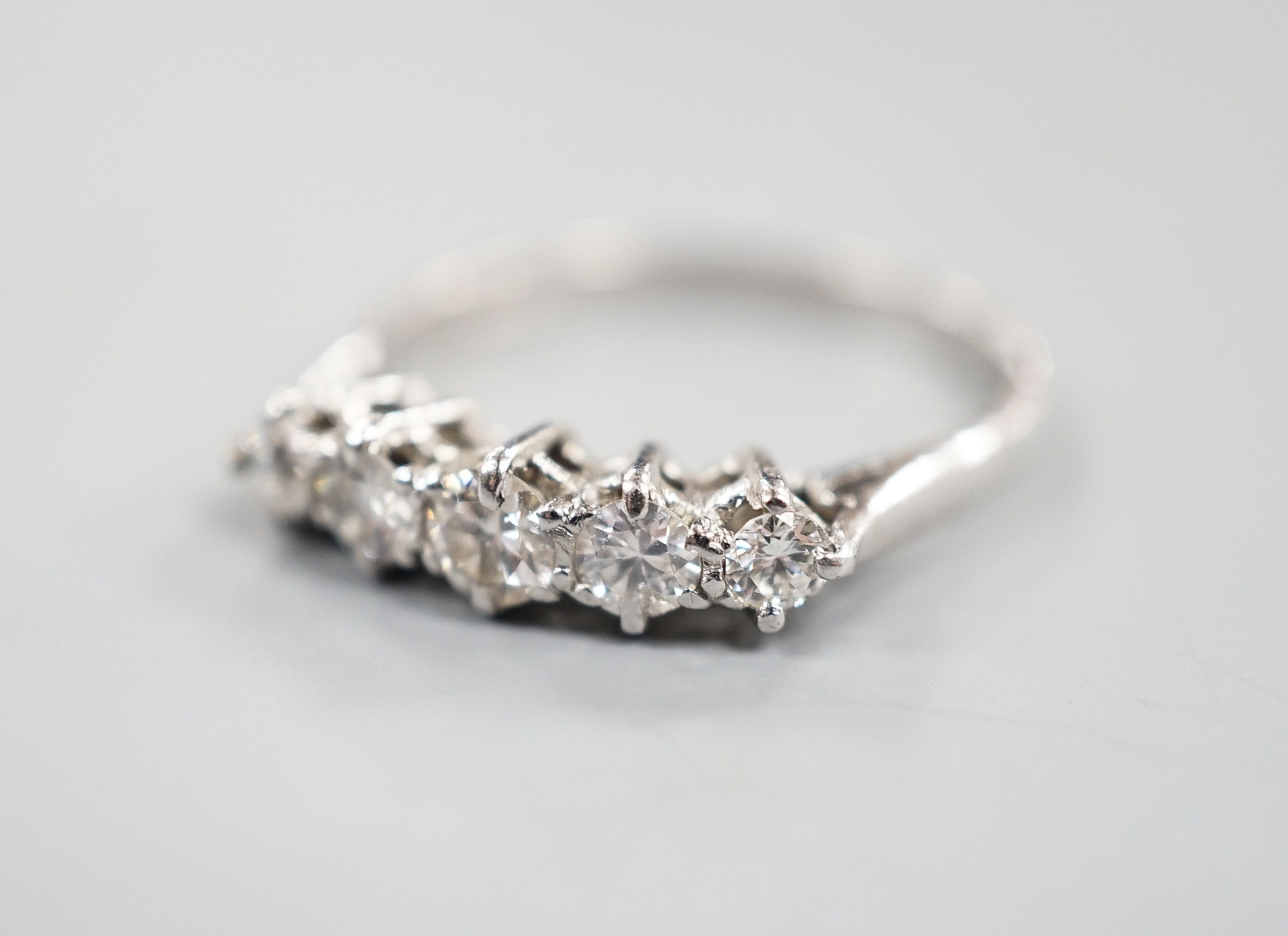 An 18ct white metal and graduated five stone diamond ring, size P/Q, gross weight 2.9 grams.
